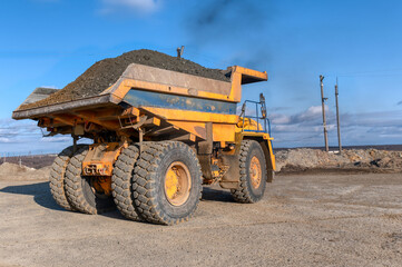 Mining truck dump truck loaded with ore. Transportation of mined ore from the open pit to the surface