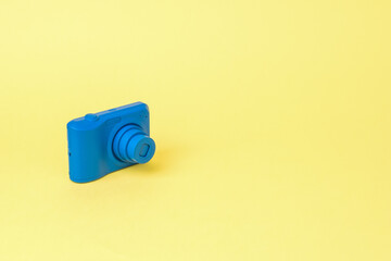 The camera is in a bright blue color on a yellow background.