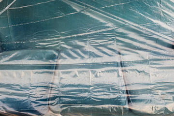 Rain drops on protective plastic covering old couch