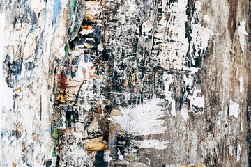 Close up peeling and decaying posters on building wall