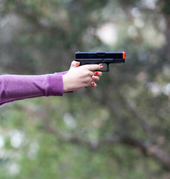 Teenage girl shooting an airsoft gun