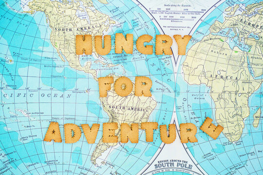 Letter shaped cookies saying Hungry for adventure on old style world map