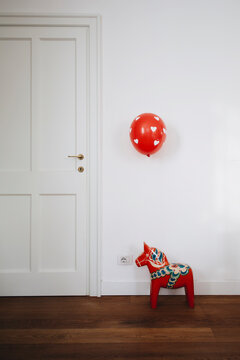 Red and white heart decorated balloon floating over original swedish decorated horse