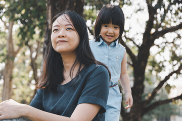Naklejka premium Asian little daughter and her mom in the park. Concept for family relationship and relaxing time.