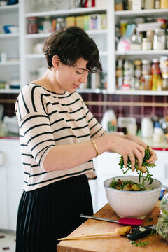 Tossing salad in the kitchen.