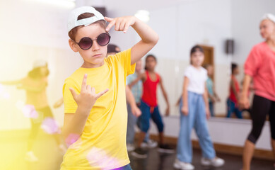 Portrait of boy hip hop dancer exercising with friends at dance class