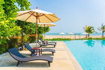 Umbrella and chair around outdoor swimming pool in hotel resort