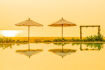 Umbrella and chair around outdoor swimming pool in hotel resort