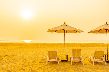 Umbrella and chair around outdoor beach sea ocean at sunset or sunrise