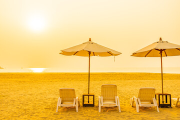 Umbrella and chair around outdoor beach sea ocean at sunset or sunrise