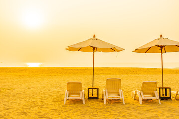 Umbrella and chair around outdoor beach sea ocean at sunset or sunrise