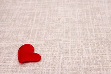 One red heart is located on a linen cloth. The concept of love and Valentine's Day. February 14 ideas.