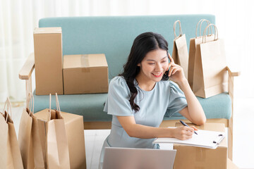 Young asian girl sitting at home selling online