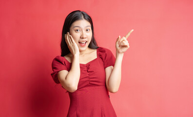 Portrait of young girl wearing red dress with expression on background