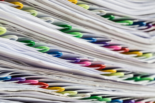 Colorful paperclips used for sorting and marking in a stack of papers