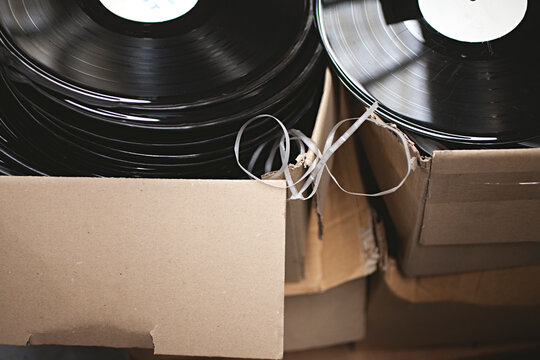 A box of damaged records sit in a box to be recycled