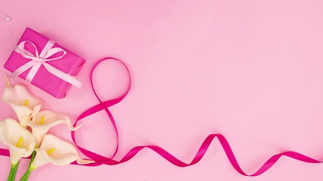 Pink ribbon, flowers and gift appear on pink theme. Stop motion