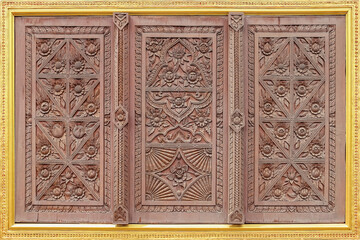 Old wooden windows carved in golden stucco frames. In the walls of temples in thailand