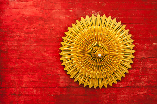 Elaborate yellow light on weathered red ceiling
