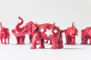 United States Republican Elephant Standing infront of A Row of Red Elephants