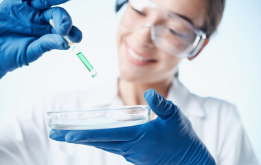 doctor in medical gloves and glasses holds a flask with liquid laboratory chemical element