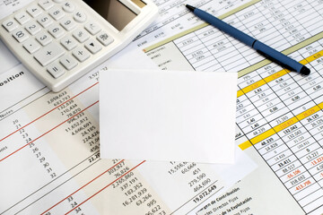 Business and financial concept. A white blank sheet with space for text on the financial document. White calculator and pen.