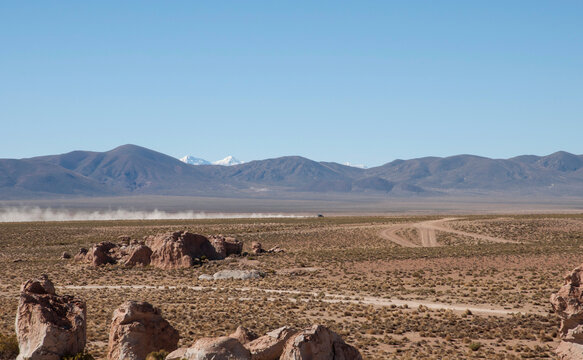 Landscape of a remote region with an overland vehicle in the dis