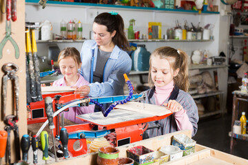 .Schoolgirls learn patiently carving under the supervision of a teacher