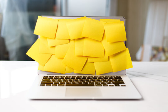Laptop screen covered by yellow adhesive notes.