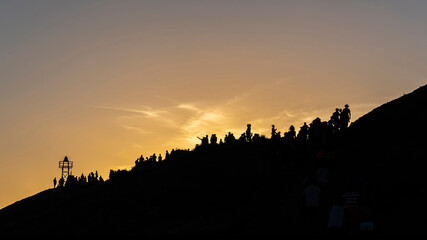 Naklejka premium Silhouettes of people on a hill gazing the sunset