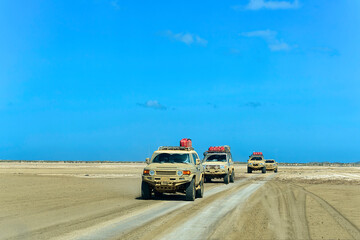 Convoy of muddy campers on a desert on a sunny day