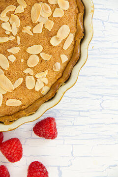 Bakewell Tart with toasted flaked almonds and raspberries, with copy space