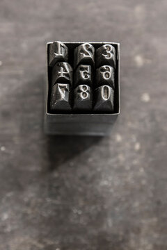 Set of numerical die stamps in tin box