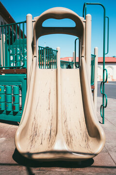 Scuffed Up Double Slide In School Playground