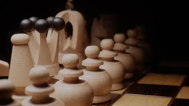 Chess pieces ready for a game. Light flashing over a chess board. Elegant woman with red polished nails making a move in a game of chess. Inteligent woman, female leadership concept.