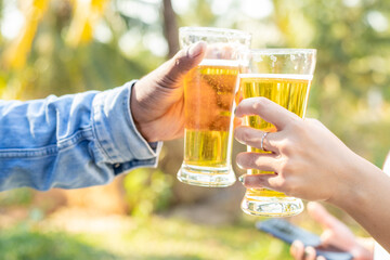 Two friends were happy toasting glasses and drinking beer on vacation.