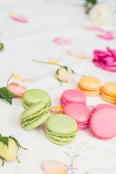 macarons and roses on an embroidered cloth