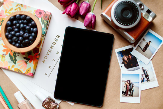 An Blank Ipad Surrounded By A Camera & A Calendar