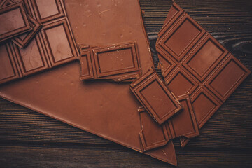 delicacy of sweet chocolate on wooden background top view texture