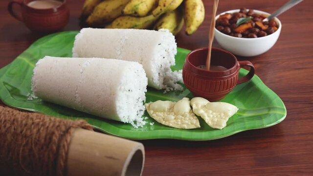 Rice Puttu white Pittu , Kadala Chickpea curry , milk tea , popular South Indian breakfast steamed rice cake 4K slow motion video footage Kerala Tamil Nadu India Sri Lanka. rice flour grated coconut  