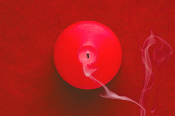 Extinguished red candle over red.