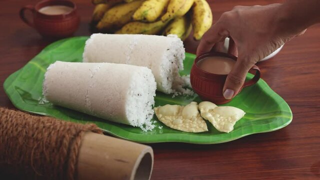 Rice Puttu white Pittu , Kadala Chickpea curry , milk tea , popular South Indian breakfast steamed rice cake 4K slow motion video footage Kerala Tamil Nadu India Sri Lanka. rice flour grated coconut  