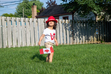 Kid citizen celebrating Canada Day holiday on first day of July. Canadian flag
