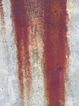Dripping rust marks on concrete wall, close up