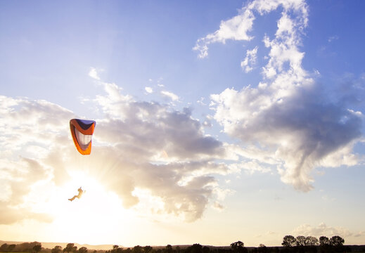 A paraglider flies past the sun