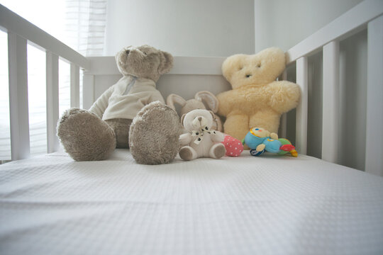 A cute crib of a baby with variety of teddies.