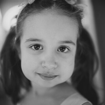 Black and white close up portrait of a beautiful young girl with big cheeks