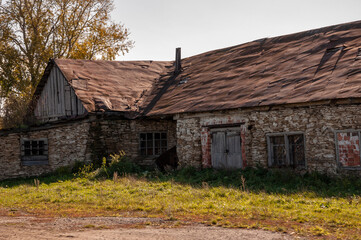 Obraz premium Lonely grey stone forgotten building on the green mountain. Deep dark grey sky. Big tree near