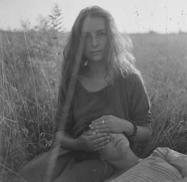 A black and white film portrait two young beautiful women lying on the grass
