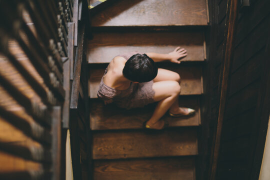 Girl sitting on wood stairs in wide brim hat